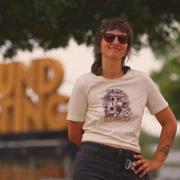 Femme posant debout, avec le trop top beige du Dub Camp 2026